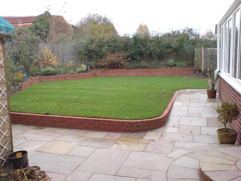 A sloping garden that has been levelled with a retaining wall to provide a level lawn. A new patio has also updated the previously tired garden