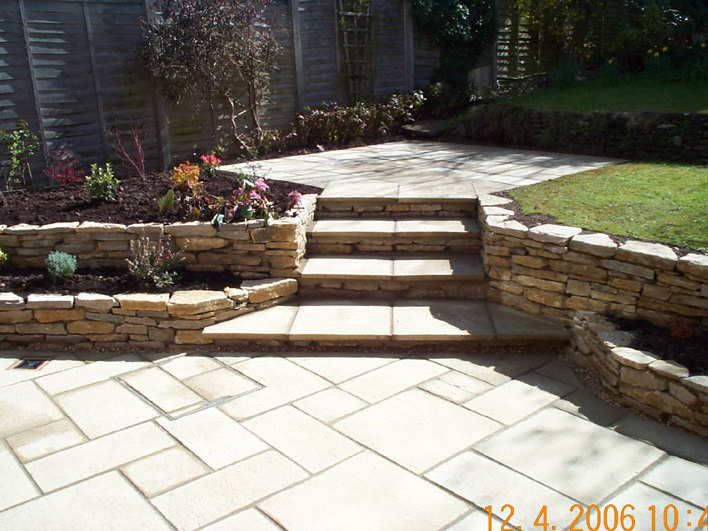 Dry stone walls have been used to create a new patio area around a new conservatory