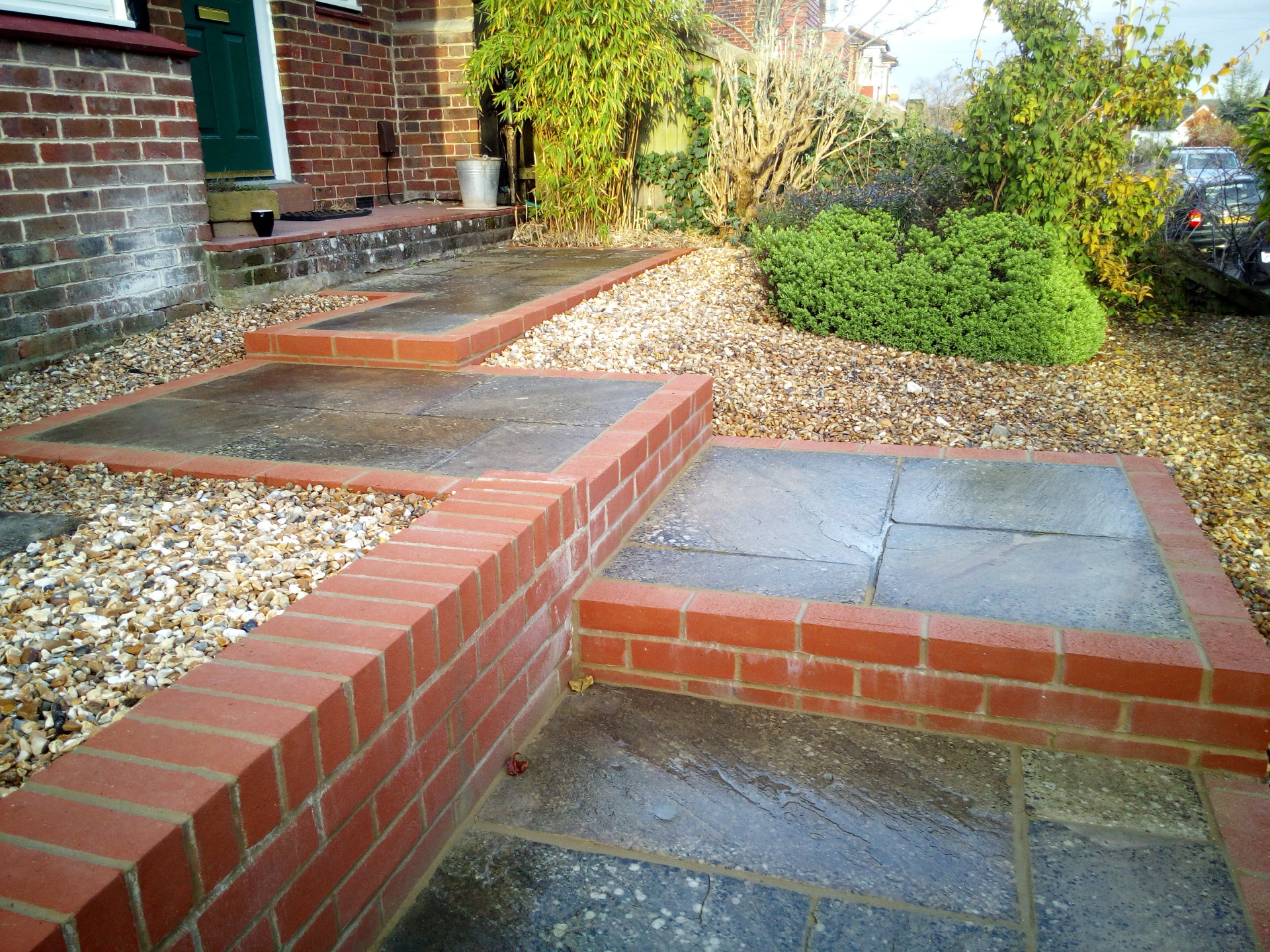 A steep sloping front garden in Winchester with paved steps, retaining wall and gabions